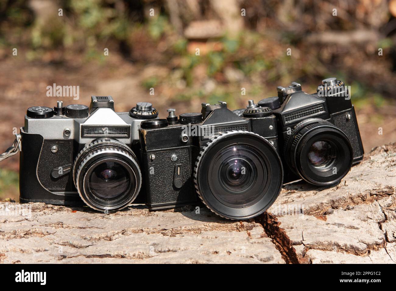 tre vecchie fotocamere professionali con obiettivi. Foto Stock