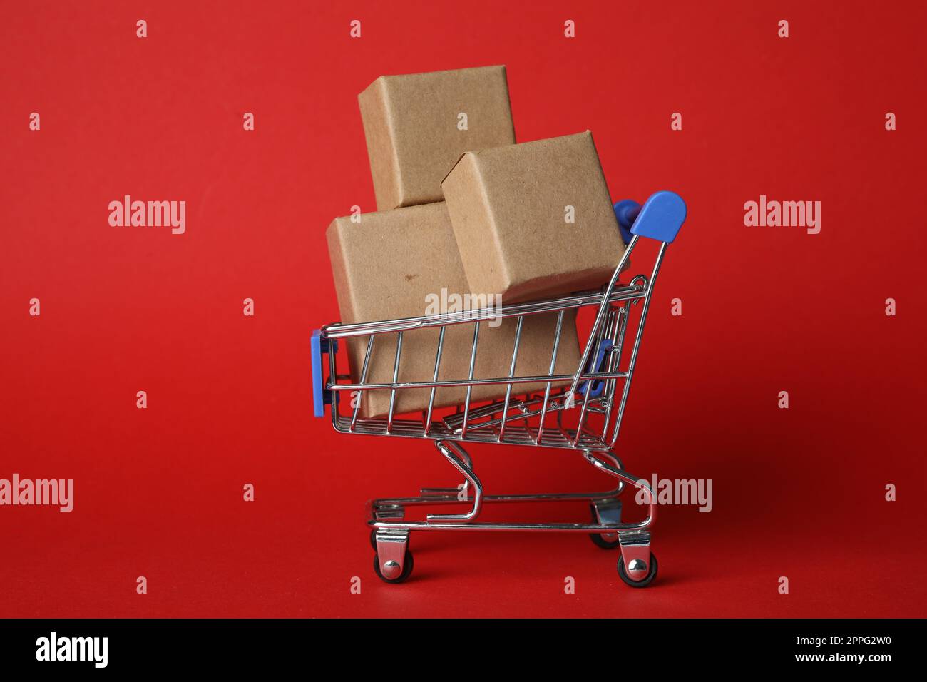Carrello con scatole su sfondo rosso. Logistica e concetto all'ingrosso Foto Stock