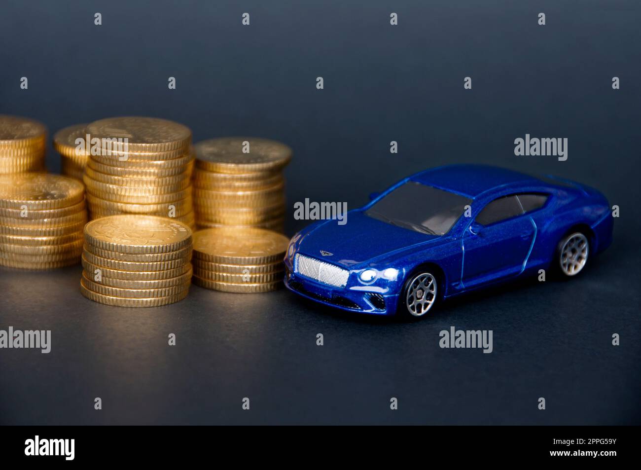 Kuala Lumpur, Malesia - luglio 2022: Macchinina in miniatura della Bentley Continental GT con monete d'oro su sfondo nero. Foto Stock