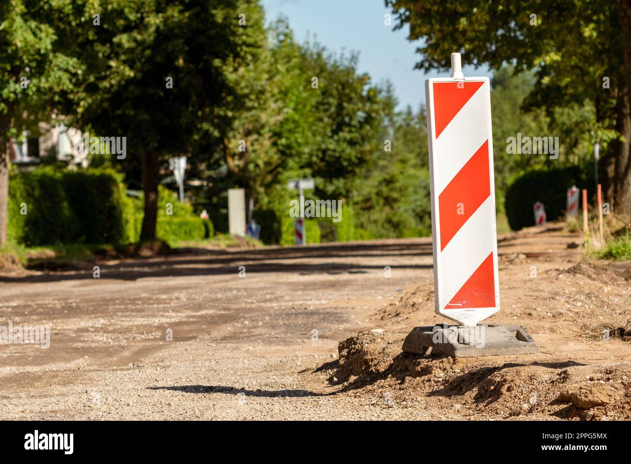 Dispositivi di controllo del traffico a strisce rosse e bianche sulla strada in riparazione Foto Stock