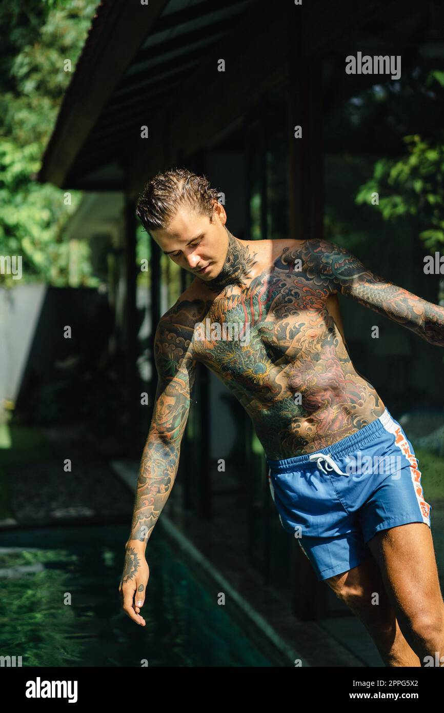 Giovane uomo bello con tatuaggi in stile giapponese. Foto Stock