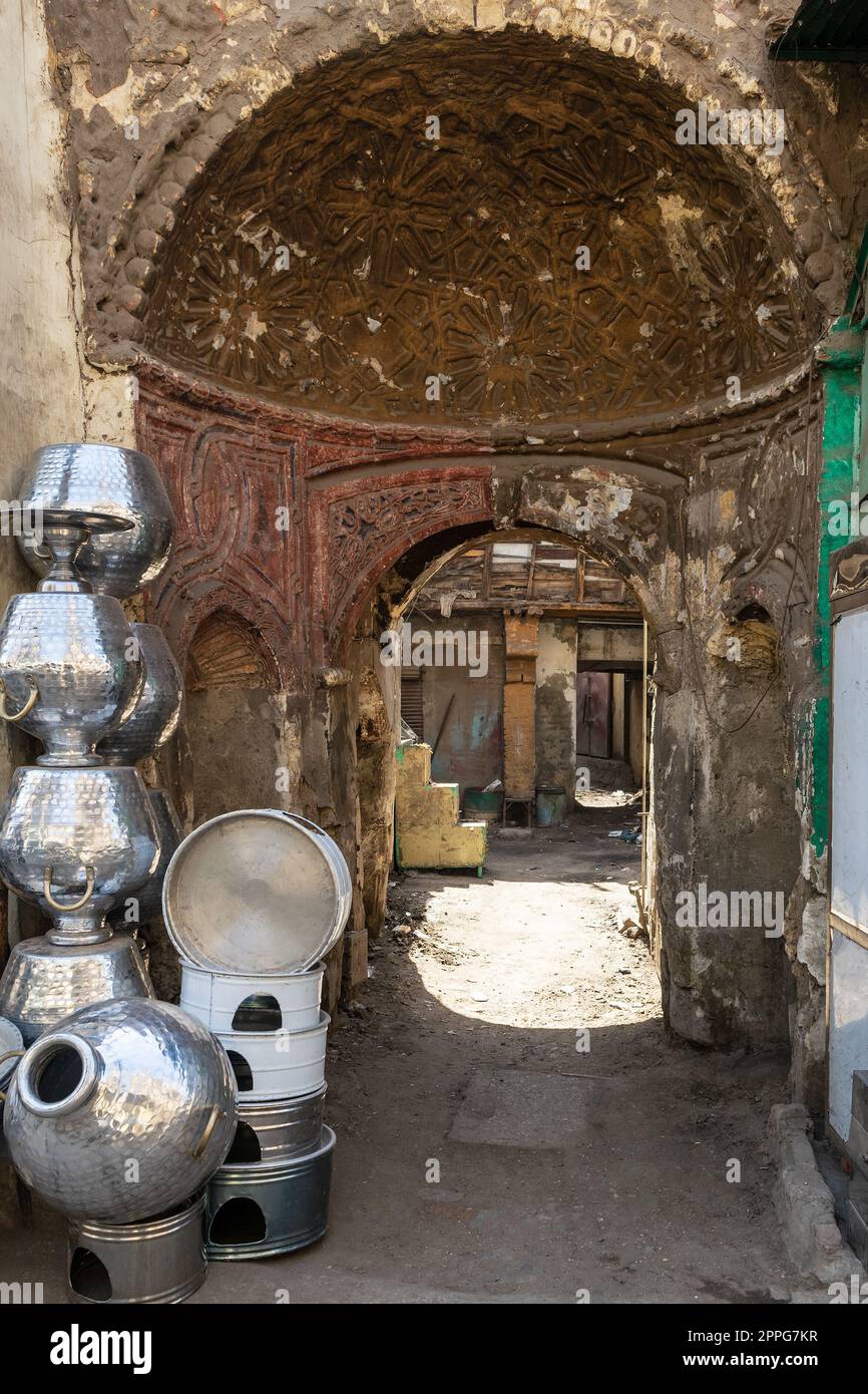 Strada stretta con vecchio edificio e tradizionali vasi in alluminio egiziano, il Vecchio Cairo, Egitto Foto Stock
