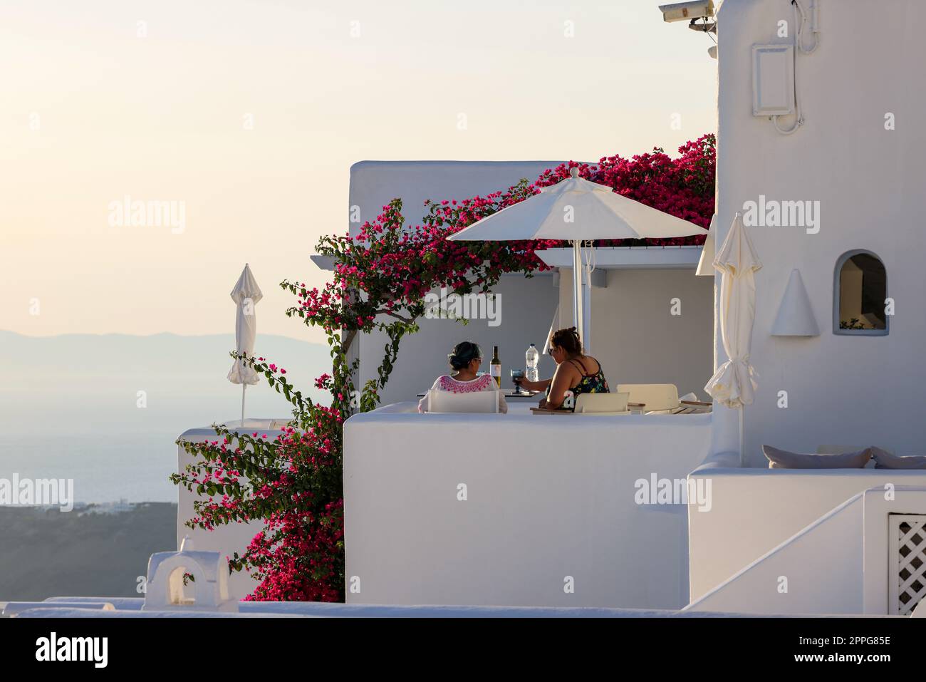 Bouganvillea rossa che si arrampica sulla parete della casa imbiancata a Imerovigli sull'isola di Santorini Foto Stock