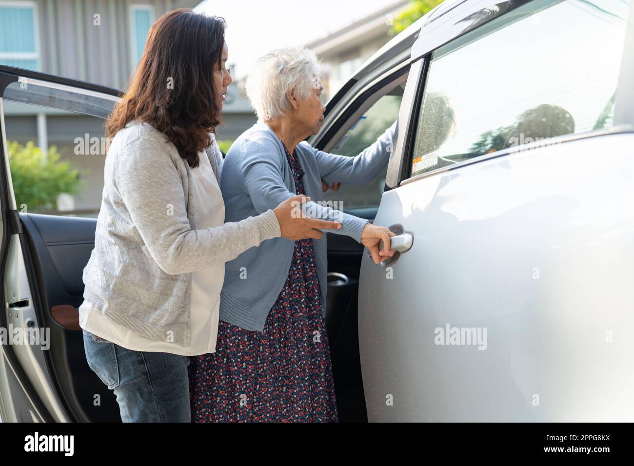 Caregiver aiutare asiatico anziano o anziano donna anziana paziente donna ottenere alla sua auto, sano forte concetto medico. Foto Stock