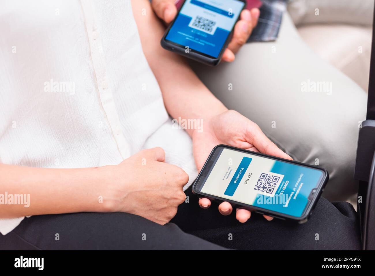 Viaggiatore donna in possesso di passaporto sanitario di certificazione di vaccinazione sull'app per smartphone Foto Stock
