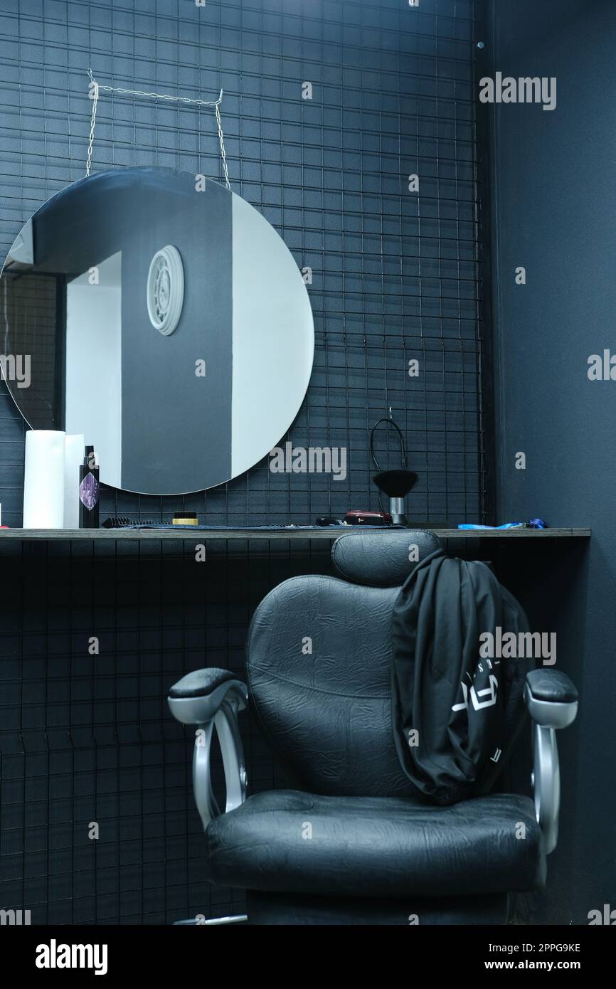 Sedia del cliente nel barbiere in pelle nera con interni neri Foto Stock
