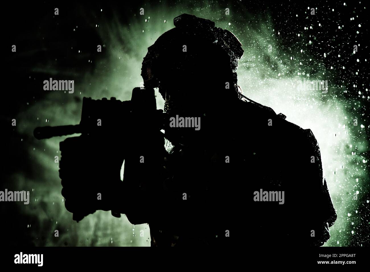 Soldato di puntamento fucile di servizio sotto la pioggia durante la notte Foto Stock