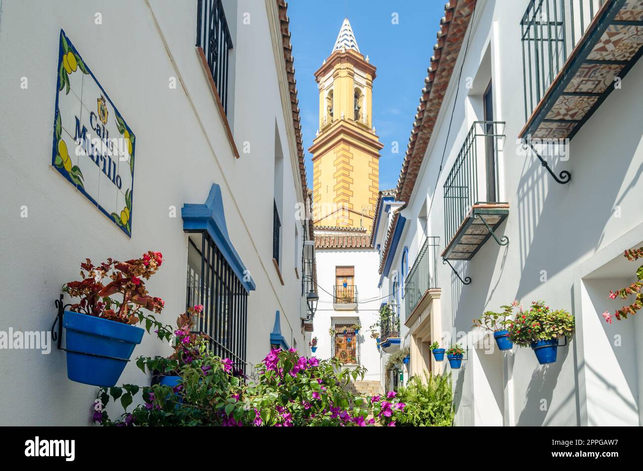 ESTEPONA, SPAGNA - 12 OTTOBRE 2021: Strade strette nel centro di Estepona, tipica città andalusa, con case bianche adornate con vasi di fiori colorati situati sulla Costa del Sol, provincia di Malaga, Spagna meridionale Foto Stock