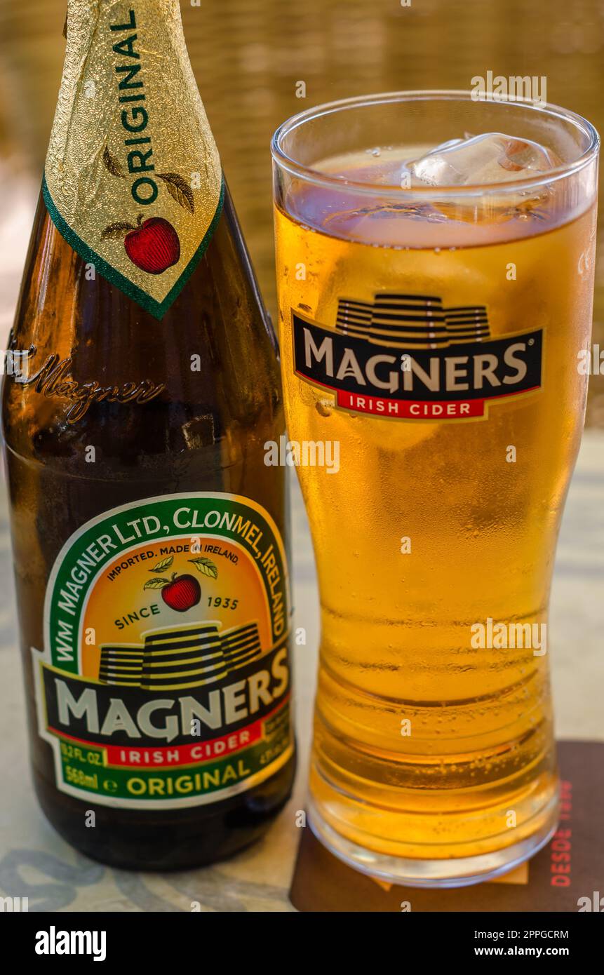 FUENGIROLA, SPAGNA - 10 OTTOBRE 2021: Bottiglia di sidro irlandese Magners, servita refrigerata in un bicchiere con il logo Magners Foto Stock