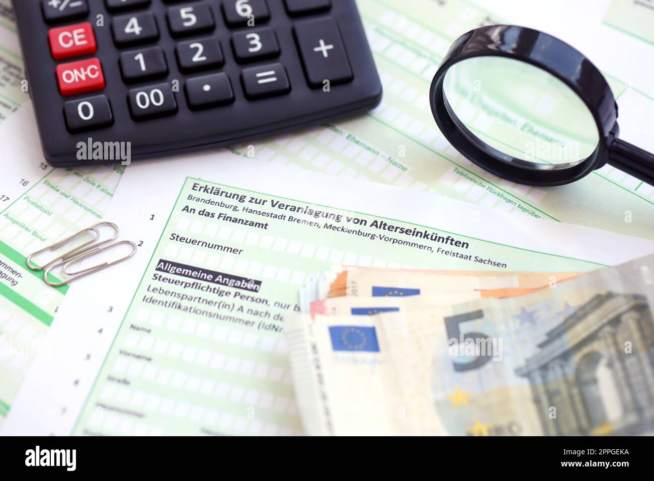 Dichiarazione tedesca sulla valutazione del reddito pensionistico con calcolatore e primo piano del denaro europeo. Il concetto di tassazione e di pratiche contabili Germania Foto Stock