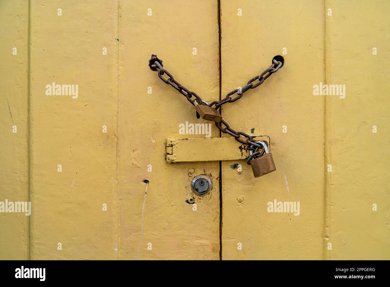 serratura a catena sulla porta gialla in legno. spazio di copia Foto Stock
