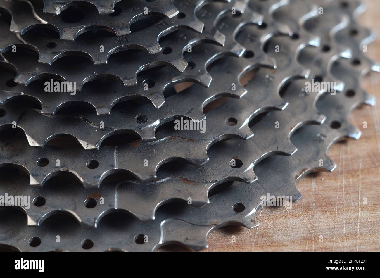 Cassetta posteriore (ruota dentata) di una mountain bike adagiata su un tavolo di legno in un negozio di biciclette Foto Stock