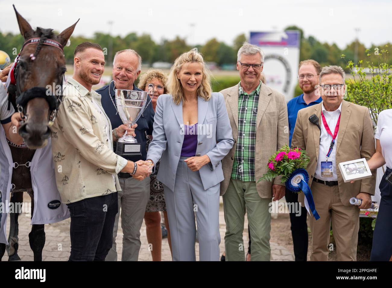 Veronica Ferres ( attrice ) e Andreas Haase ( amministratore delegato della Berlin Trotting Association ) alla Super Trot Cup 2022 al proprietario Remon Hendriks la coppa del vincitore sulla pista di trotto Mariendorf. Foto Stock