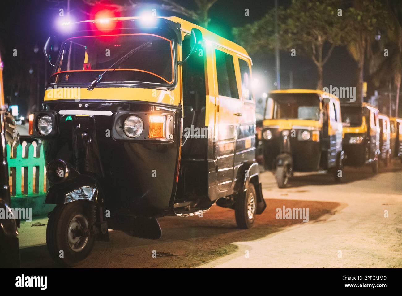 Goa, India. Risciò automatico o tuk-tuk parcheggiati sulla strada per il noleggio delle luci notturne Foto Stock