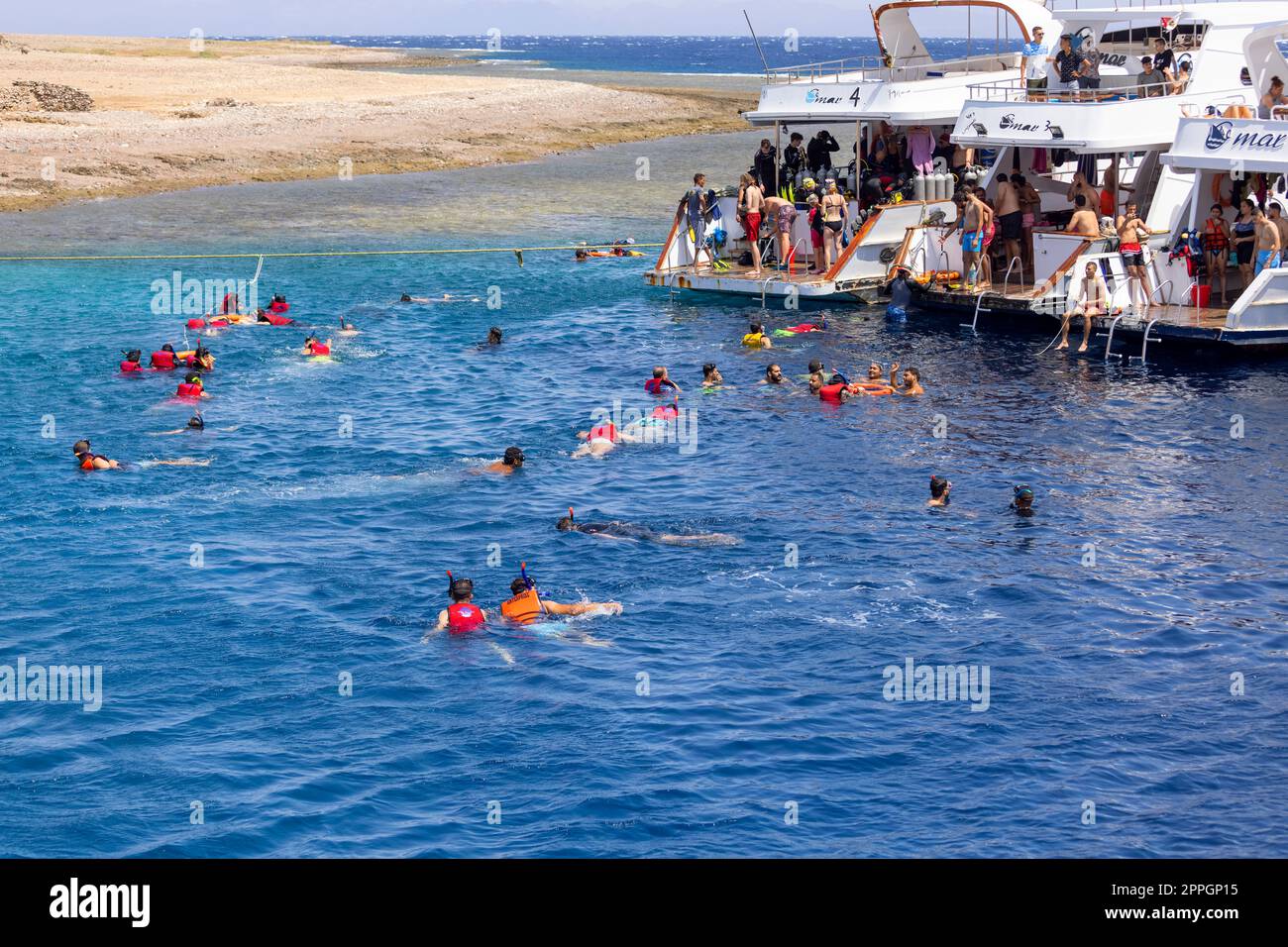 Dahab, Egitto - 10 settembre 2021: Gruppo di persone in giubbotti di salvataggio snorkeling nel Mar Rosso su una barriera corallina Foto Stock