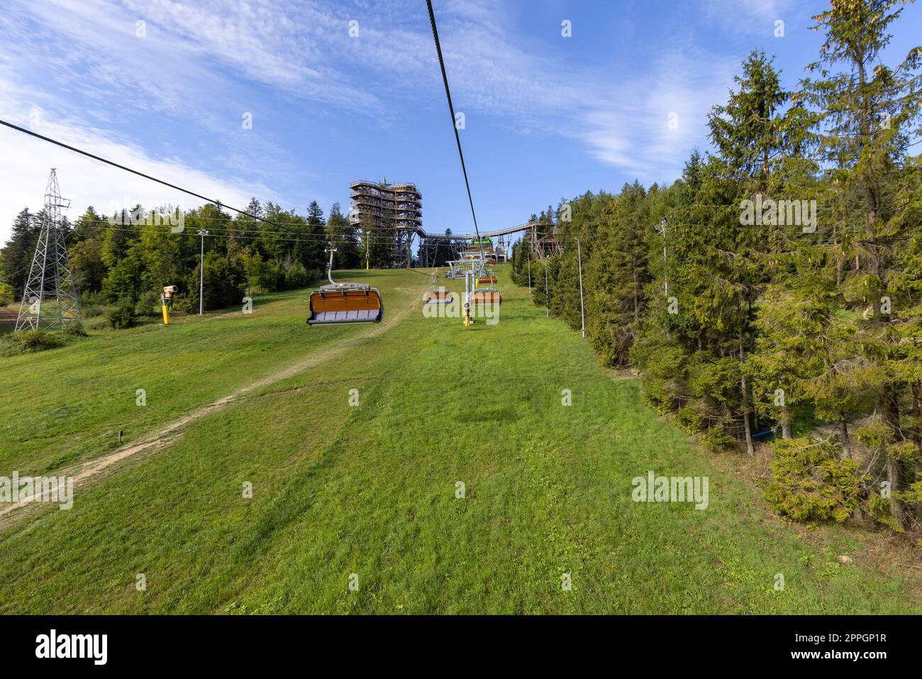 Vista della seggiovia della montagna con la torre di osservazione situata in cima alla stazione sciistica di så‚otwiny Arena, Krynica Zdroj, Beskid Mountains, Slotwiny, Polonia. Foto Stock