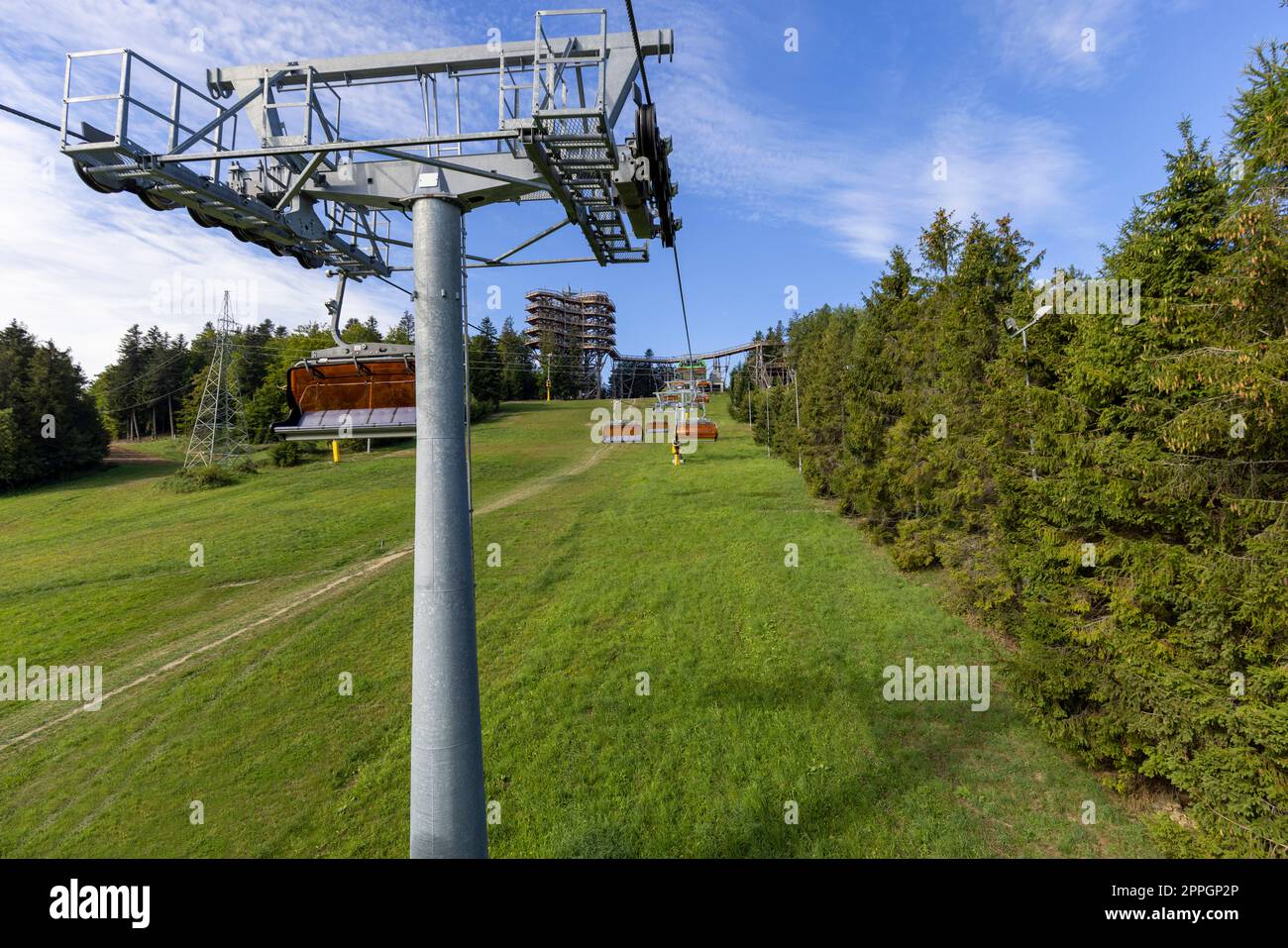 Vista della seggiovia della montagna con la torre di osservazione situata in cima alla stazione sciistica di så‚otwiny Arena, Krynica Zdroj, Beskid Mountains, Slotwiny, Polonia. Foto Stock