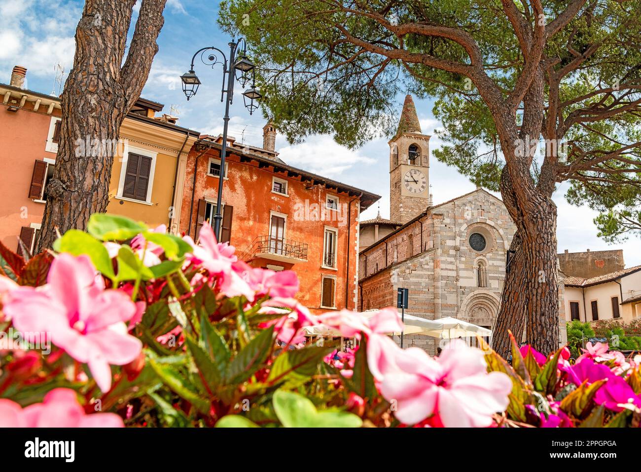 Esplanade di Maderno con fiori e antica chiesa sul Lago di Garda nel nord Italia Foto Stock