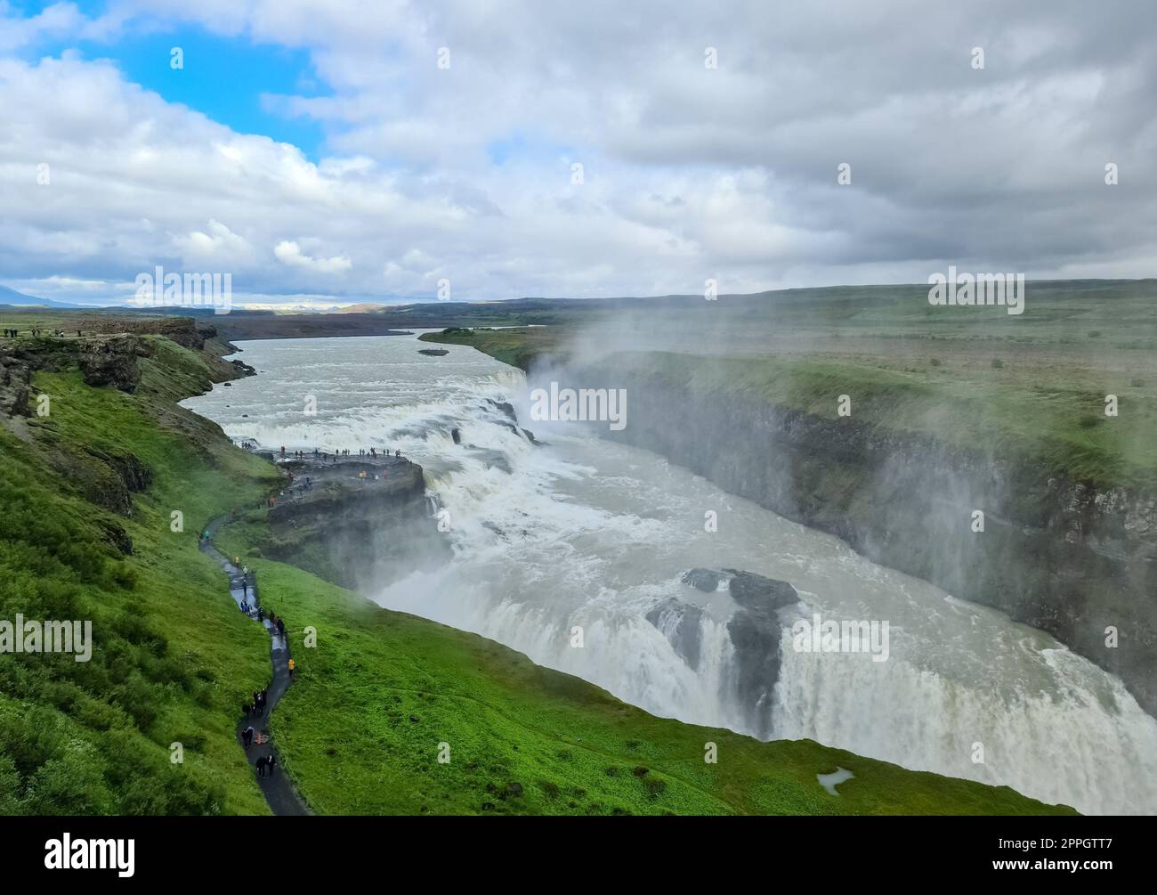 Cascata fantastica nel paesaggio dell'Islanda con rocce ed erba. Foto Stock