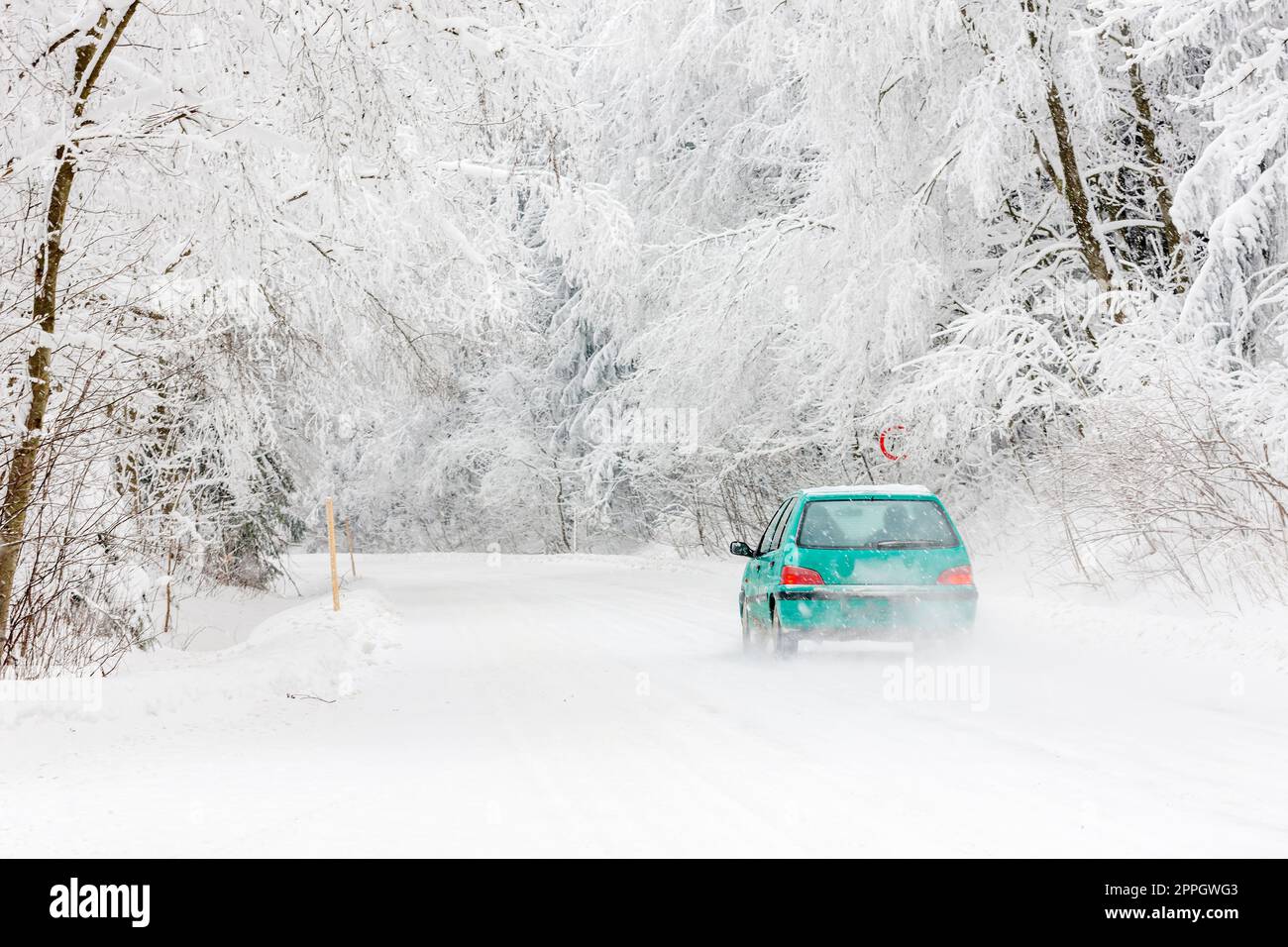 Auto verde su una strada innevata, Orlicke Mountains, Repubblica Ceca Foto Stock