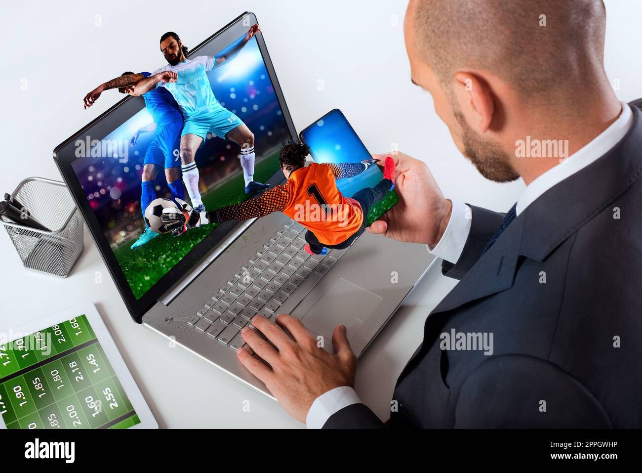 Uomo d'affari guarda la partita di calcio e le scommesse sul sito di calcio Foto Stock