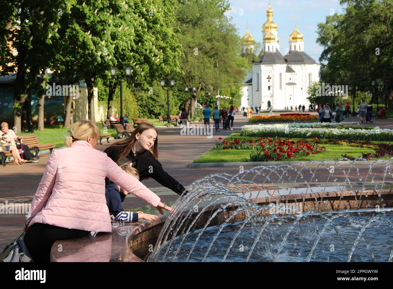 Madre e sua figlia giocano vicino alle fontane della città. Weekend divertente Foto Stock