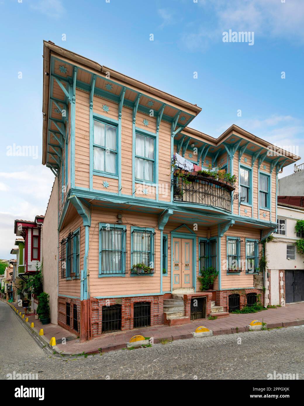 Vecchio e colorato edificio residenziale in legno con porta, finestre in ferro battuto, balcone e piante da arrampicata, Istanbul, Turchia Foto Stock