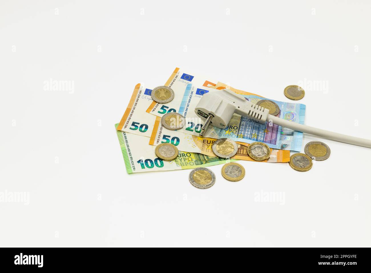 L'alimentazione elettrica si collega alle banconote e alle monete in euro. Concetto di costi di elettricità costosi Foto Stock