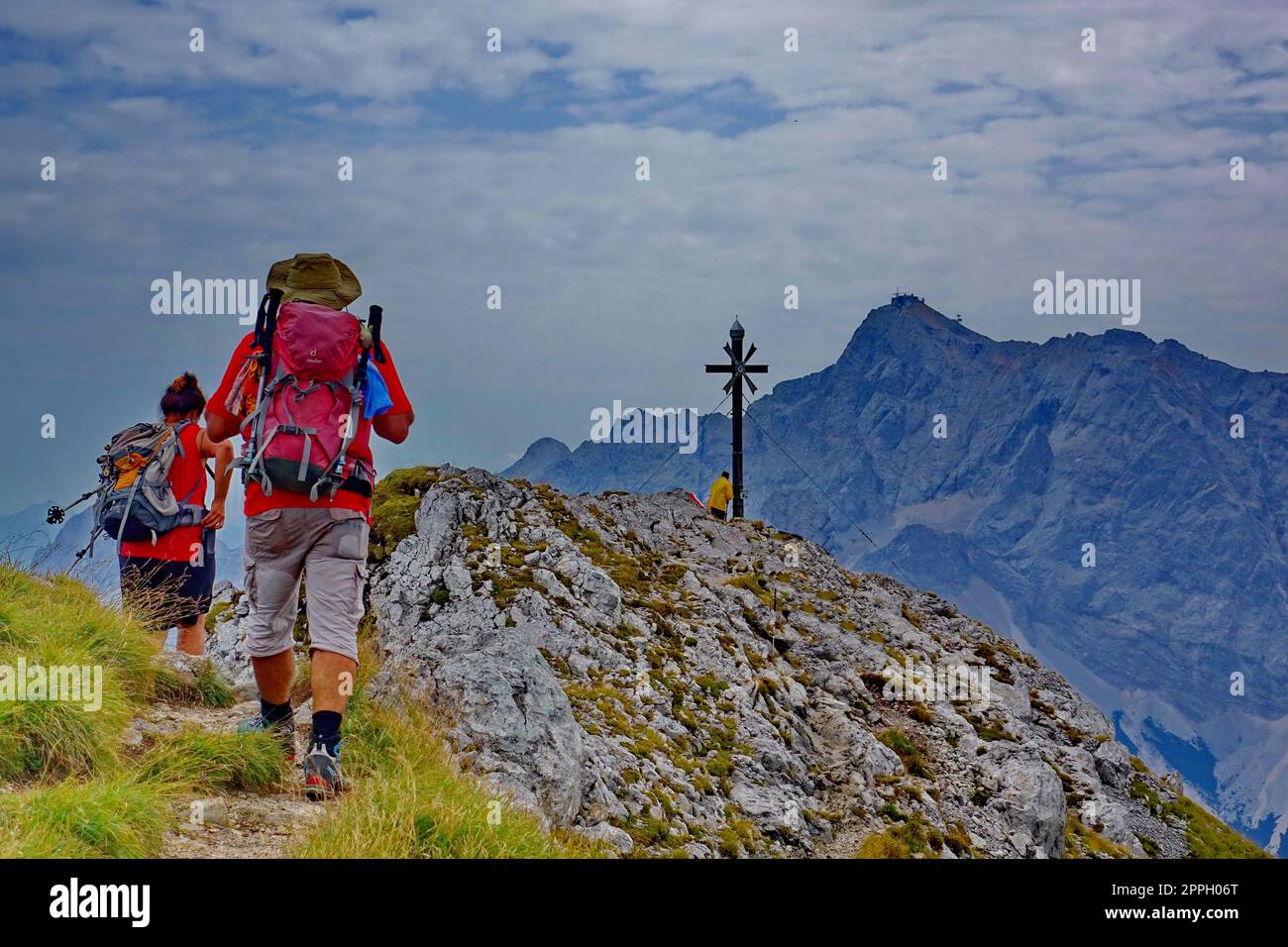 Europa, Austria, Tirolo, Alpi Ammergauer, montagna Daniel, summit Cross, coppia escursionistica, zaini, massiccio Zugspitz (sfondo) Foto Stock