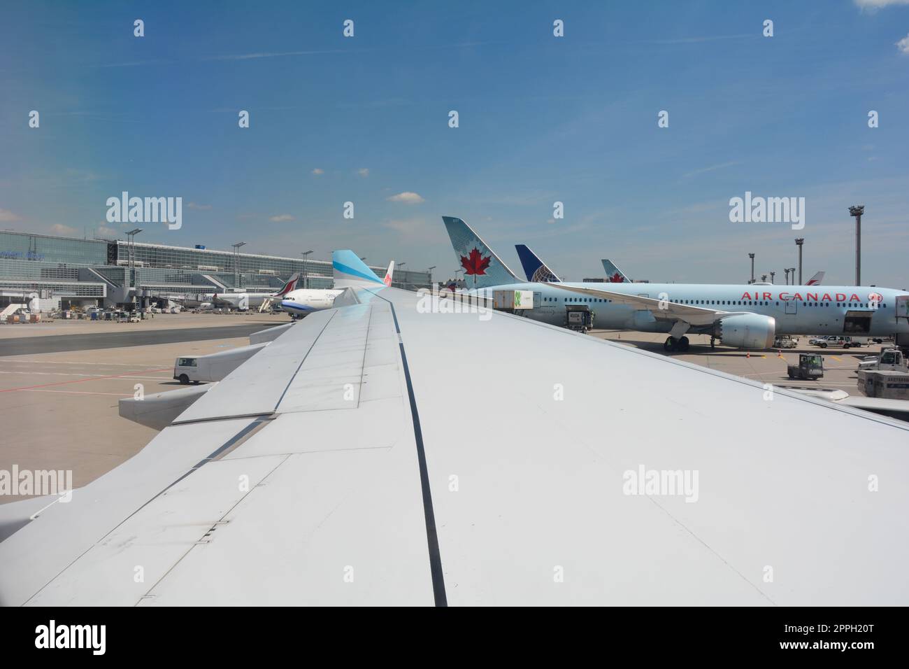 Aeroporto di Francoforte Germania 02 agosto 2022 - Vista dalla finestra dell'aeromobile su un'ala e vista di una macchina Air Canada in fase di caricamento Foto Stock