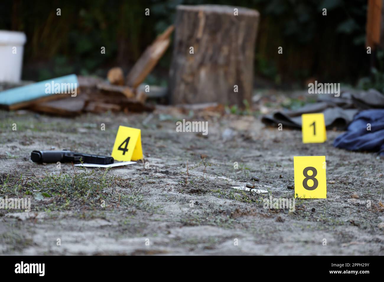 Prove con marcatore CSI giallo per la numerazione delle prove sul cortile residenziale di sera. Concetto investigativo sulla scena del crimine Foto Stock