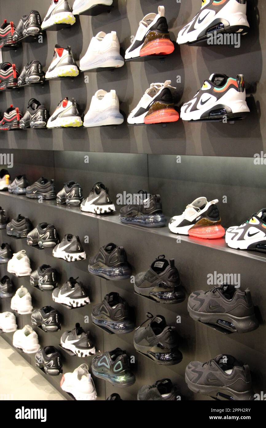 Negozio di colorazione. Sneakers sullo scaffale del negozio sportivo. Comode scarpe sportive Foto Stock