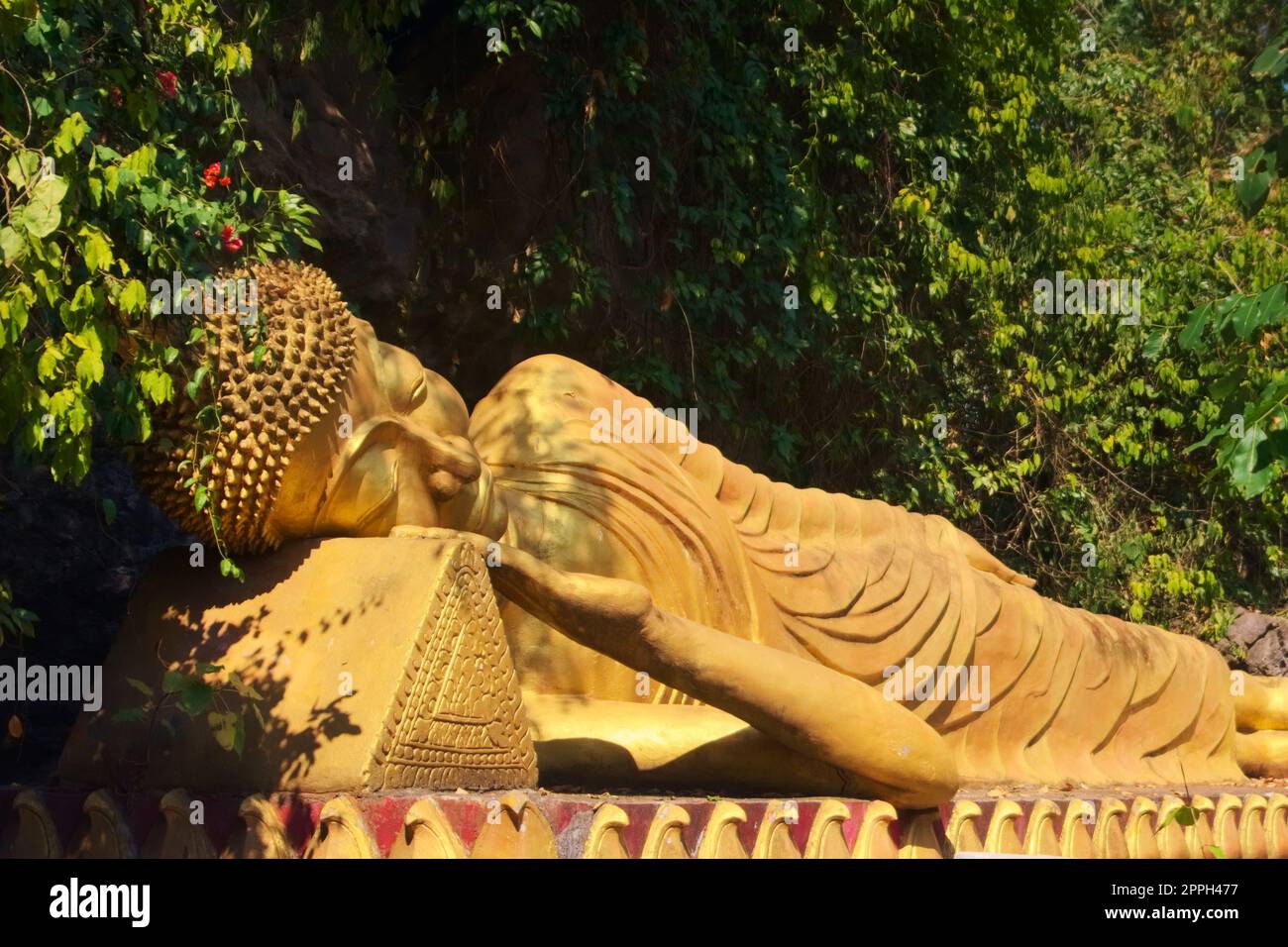 Statua dorata di Buddha reclinato sulla strada per la cima del Monte Phou si, una montagna sacra a Luang Prabang, Laos. Foto Stock