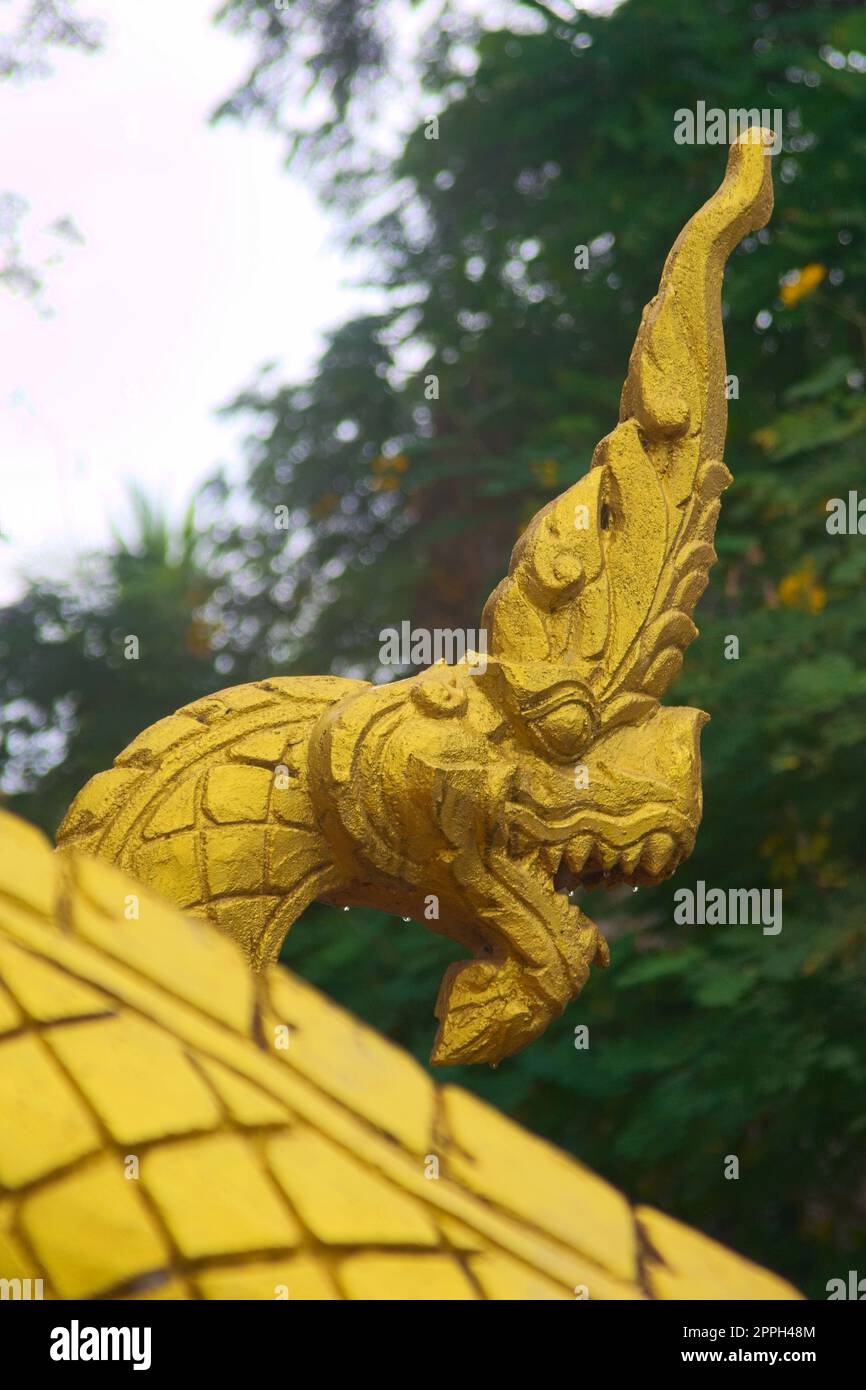 Scultura dorata di un serpente di Naga, una creatura mitologica protettrice, all'ingresso di un tempio buddista a Luang Prabang, Laos. Foto Stock