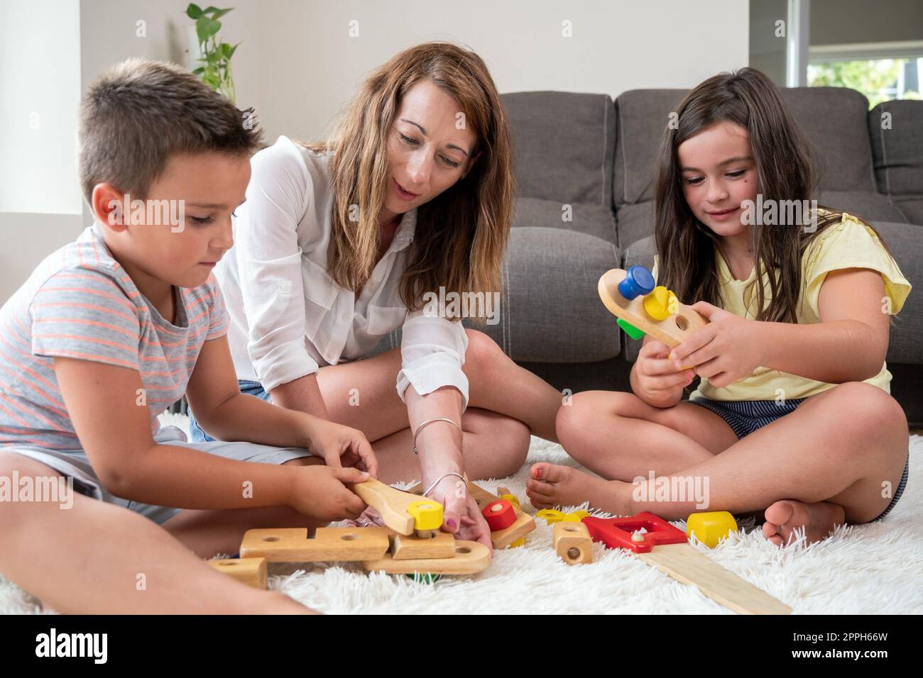 Madre single che gioca con i suoi figli a casa. Foto Stock