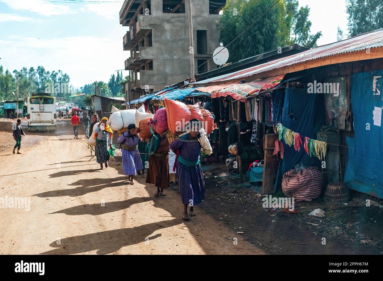 Le donne etiopi trasportano carichi pesanti sulle loro spalle in sacchi, Etiopia Foto Stock