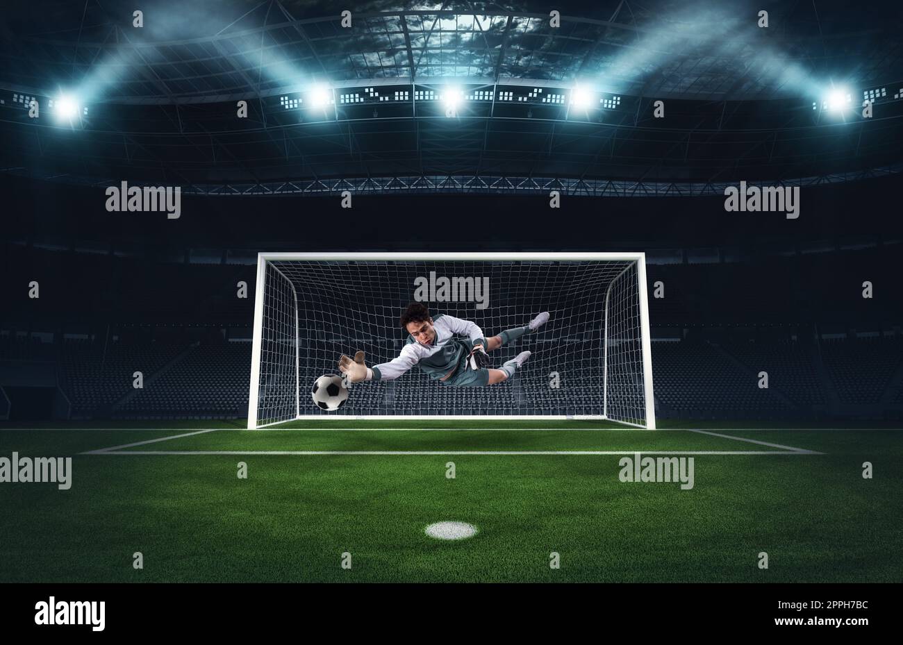 Portiere di calcio che fa un grande risparmio ed evita un gol durante una partita allo stadio Foto Stock