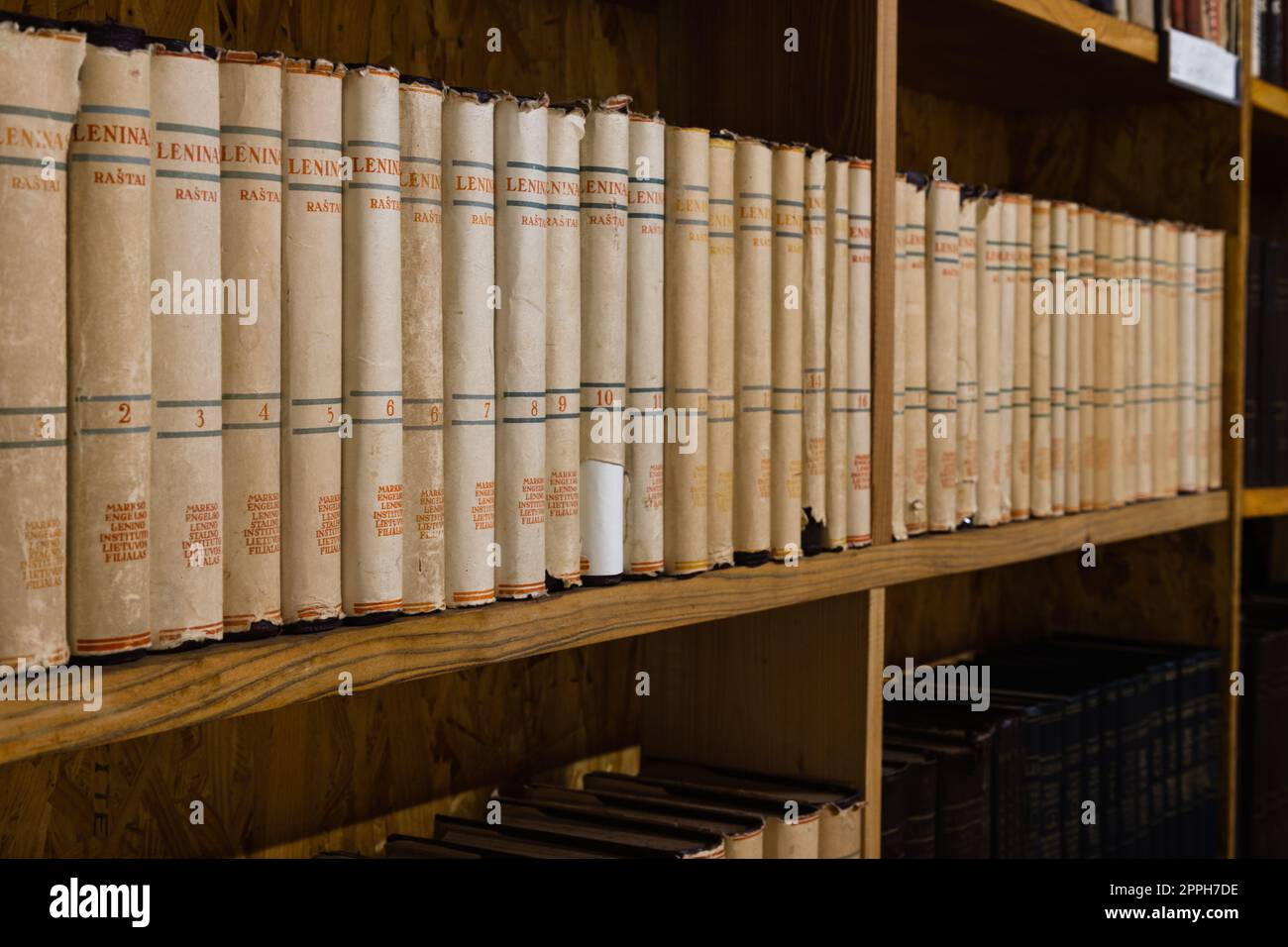Vecchi libri d'epoca su una mensola di legno nella biblioteca Foto Stock
