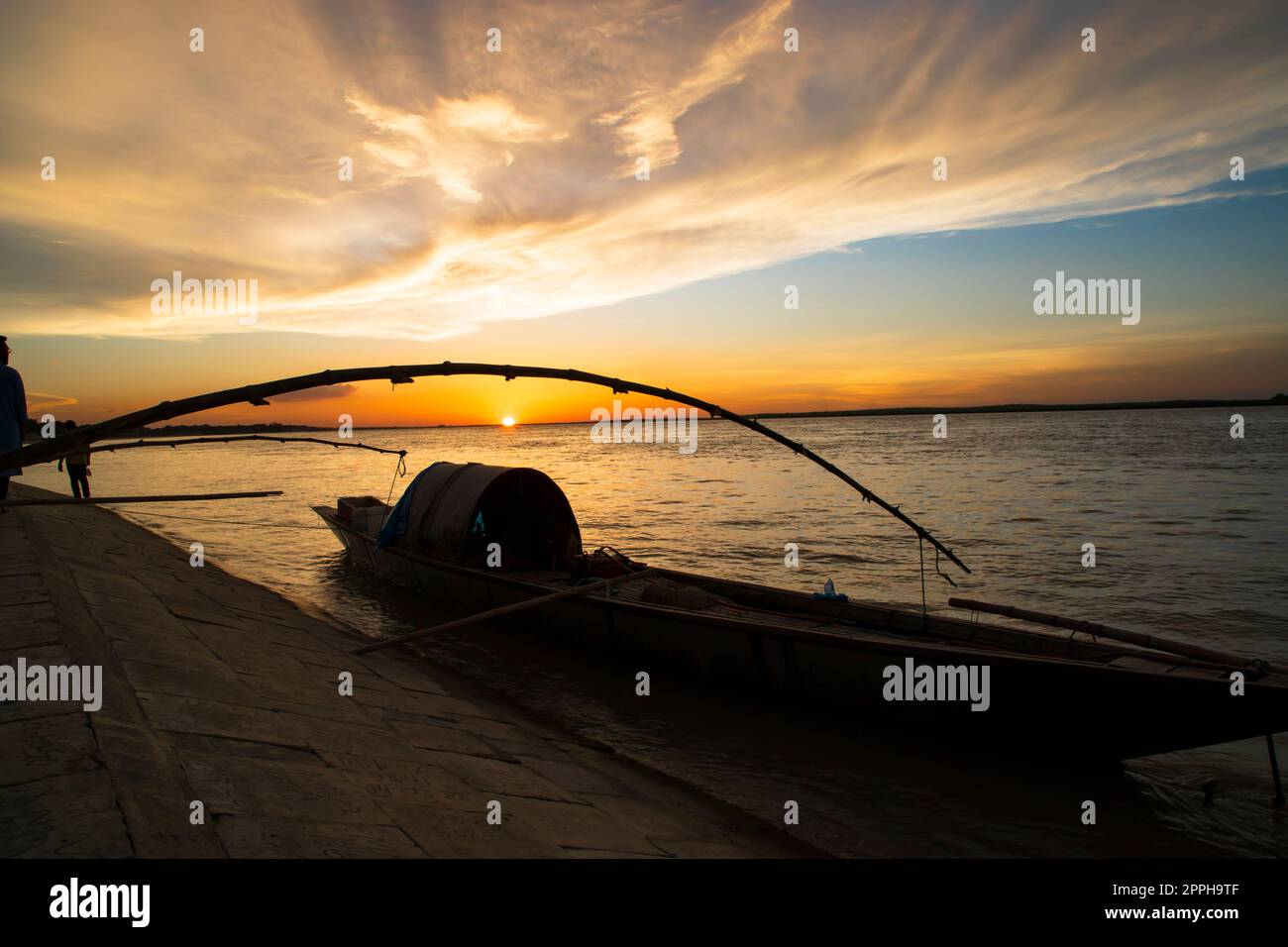 Una barca di legno sul Mare contro il Cielo durante il Tramonto Foto Stock