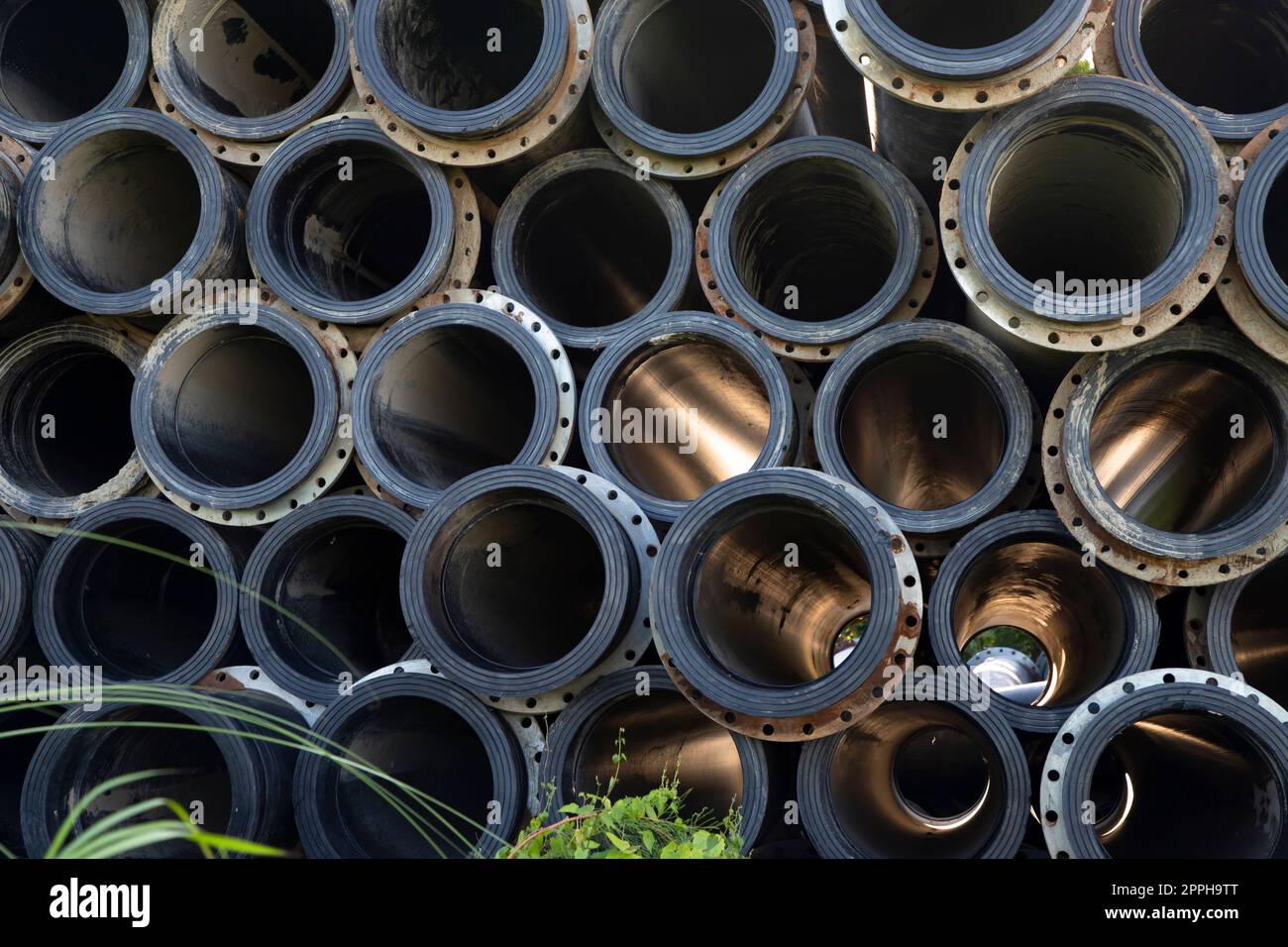 Sfondo di tubi di gomma di plastica nera usati al vestirsi di fiume. Luce attraverso i tubi Foto Stock