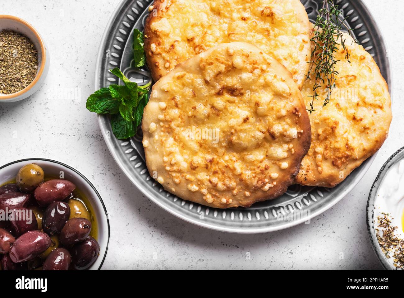 Manakeesh, pizza araba, pane piatto con formaggio a colazione. Primo piano con pane piatto mediterraneo fatto in casa. Cucina araba. Foto Stock