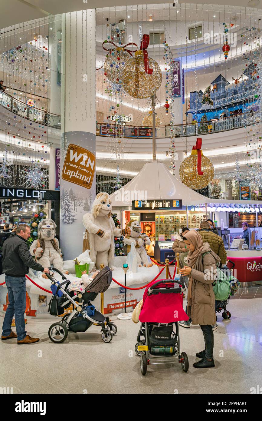 Le famiglie che visitano la scena natalizia invernale e le decorazioni nel centro commerciale Jervis, Irlanda Foto Stock