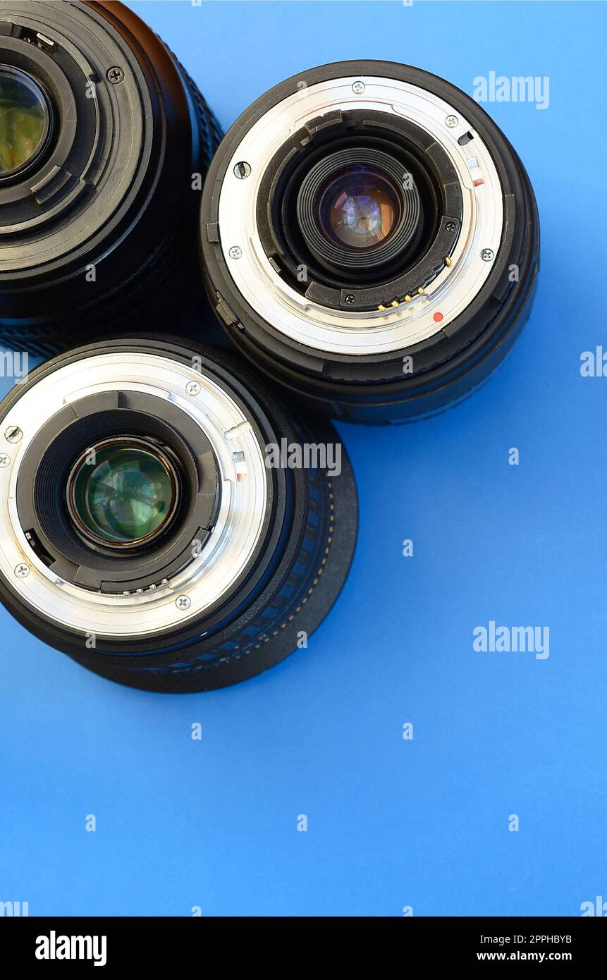 Diversi obiettivi fotografici si trovano su uno sfondo blu brillante. Spazio per il testo Foto Stock