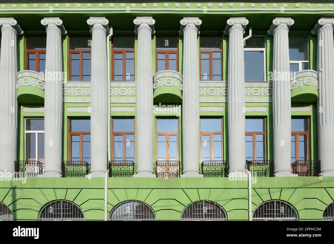 Antico edificio a più piani restaurato con antiche colonne, dipinto di verde Foto Stock