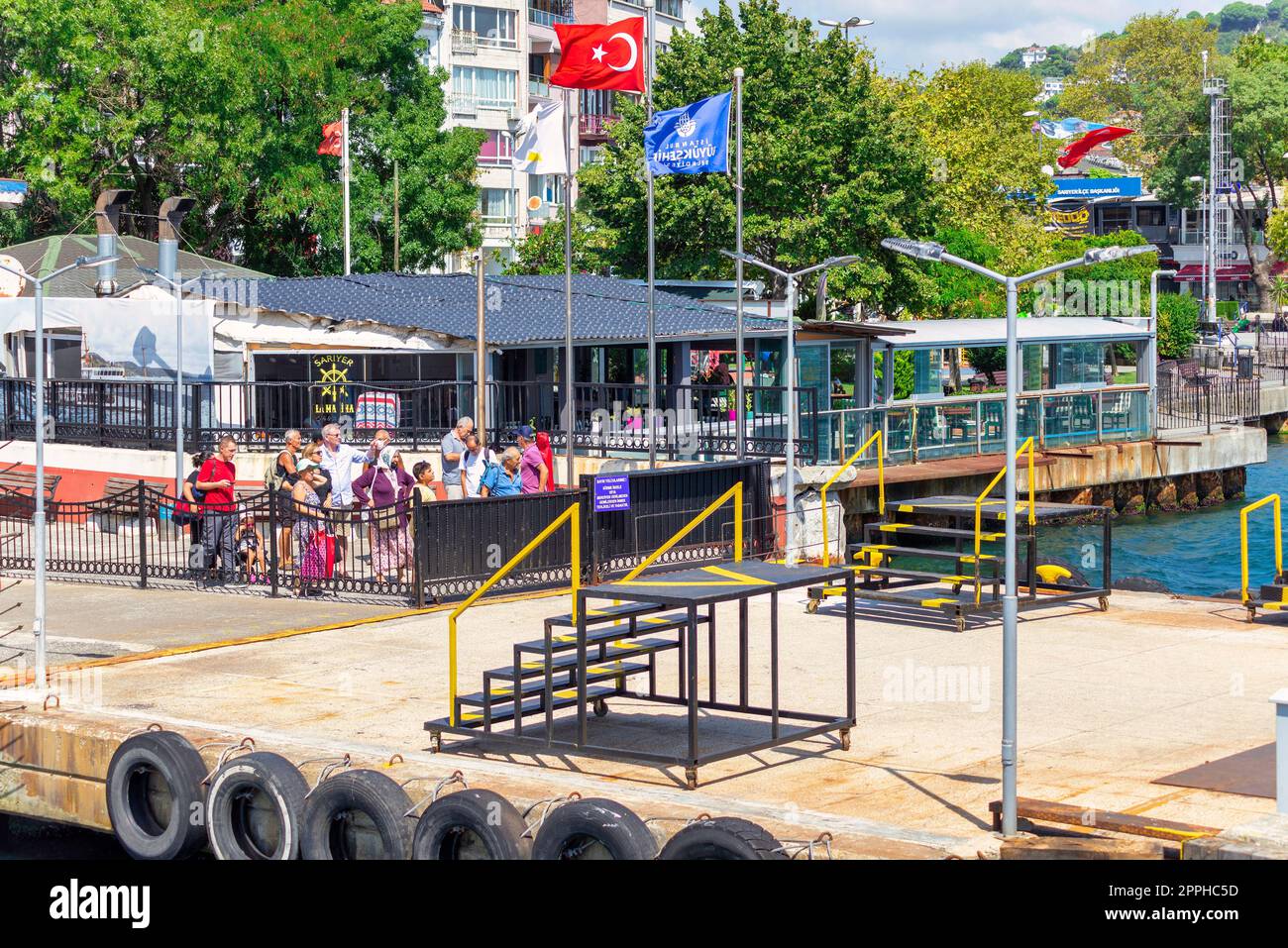 Bosforo, terminal dei traghetti Sariyer con passanti in attesa e fitti alberi verdi, Istanbul, Turchia Foto Stock