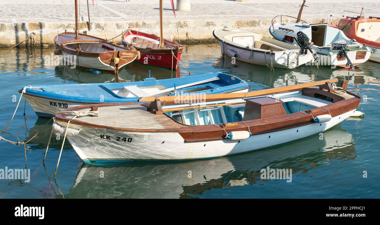 Piccole barche da pesca e barche da escursione degli abitanti della città di Krk al porto sulla costa croata del mare Adriatico Foto Stock