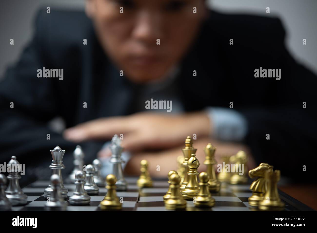 Pianificazione strategica e obiettivi successo idea di business. Uomo d'affari che guarda gli scacchi al bordo. Foto Stock