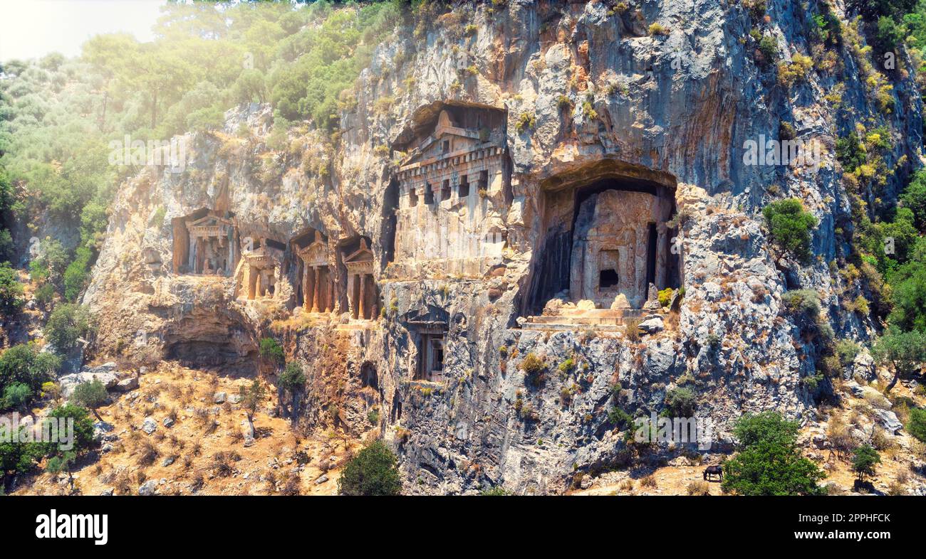 Le antiche rovine della città di Myrna vicino ad Antalya Turchia, con le spaventose tombe rocciose illuminate dal sole che tramonta. Foto Stock