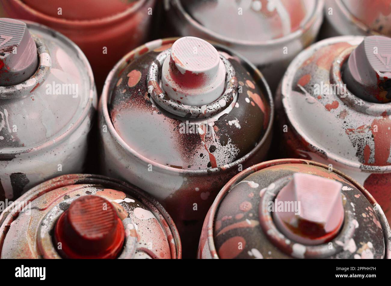 Un sacco di bombolette spray usate di vernice primo piano. Lattine sporche e sbavate per il disegno di graffiti. Il concetto di un disegno di vernice sinuoso e disattento. Immagine artistica creativa Foto Stock