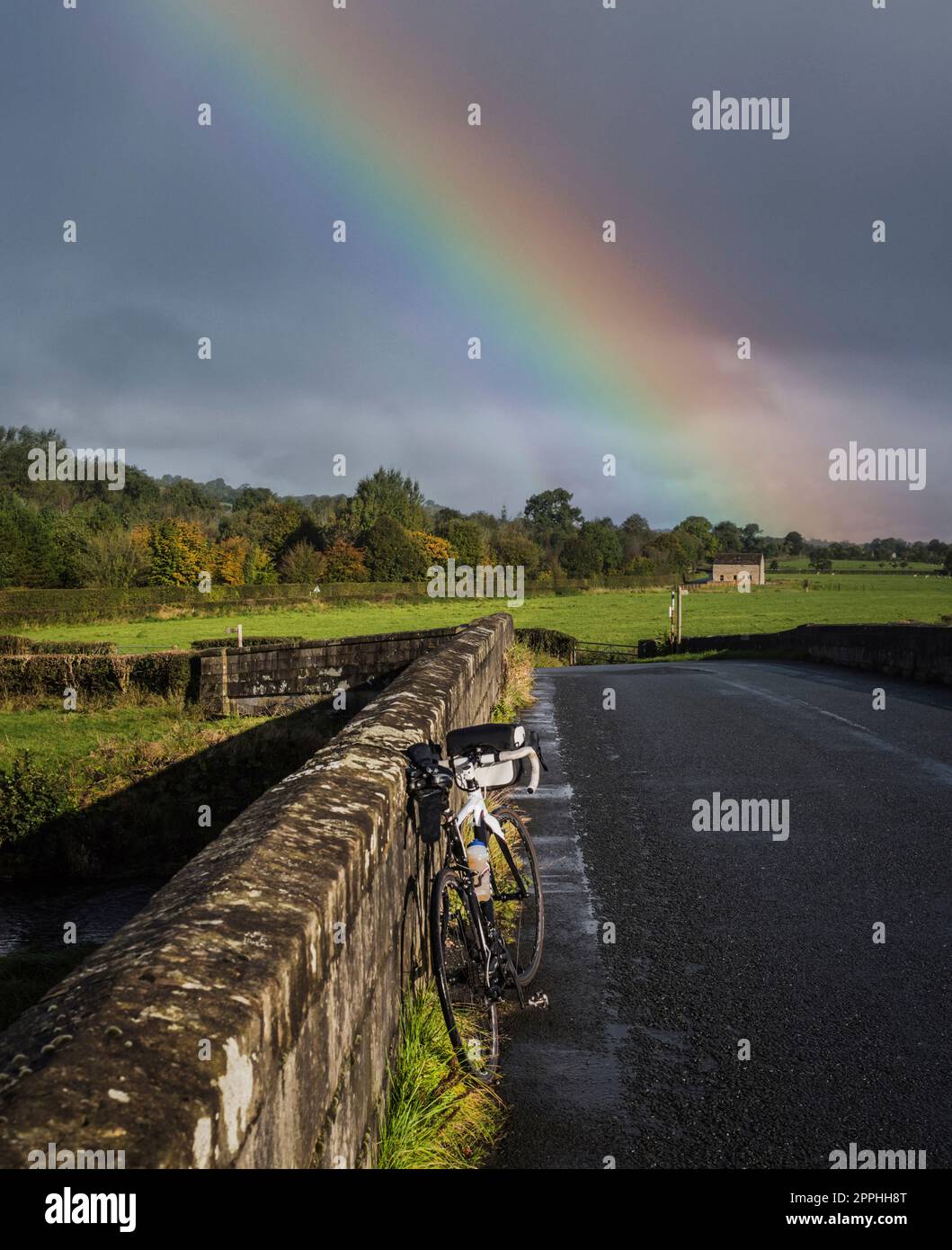 Bicicletta e arcobaleno, Sawley Bridge over the River Ribble, Lancashire, Regno Unito Foto Stock